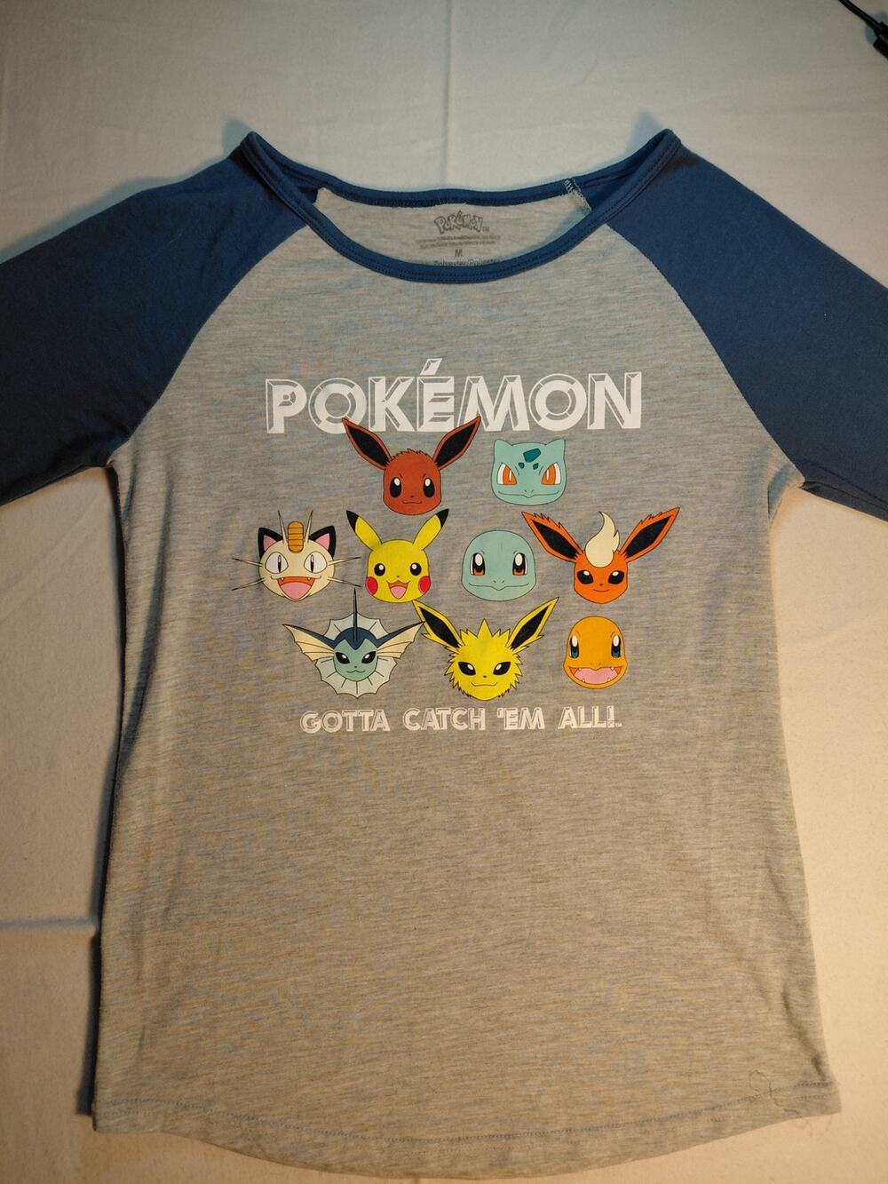 Raglan Pokémon graphic t-shirt featuring Pikachu, Eevee, and other characters